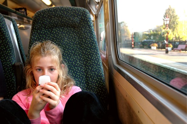 Stop obsessing over HTML5 and CSS3 Girl using a mobile phone while on a train.